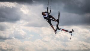 man doing foil kite surfj g under white clouds at daytime