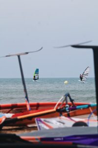 a group of people windsurfing in the ocean behind some hydrofoil surf boards