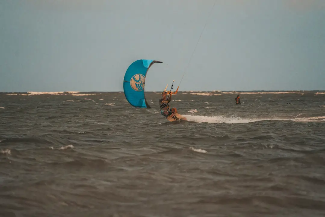 a person windsurfing in the ocean on a cloudy day