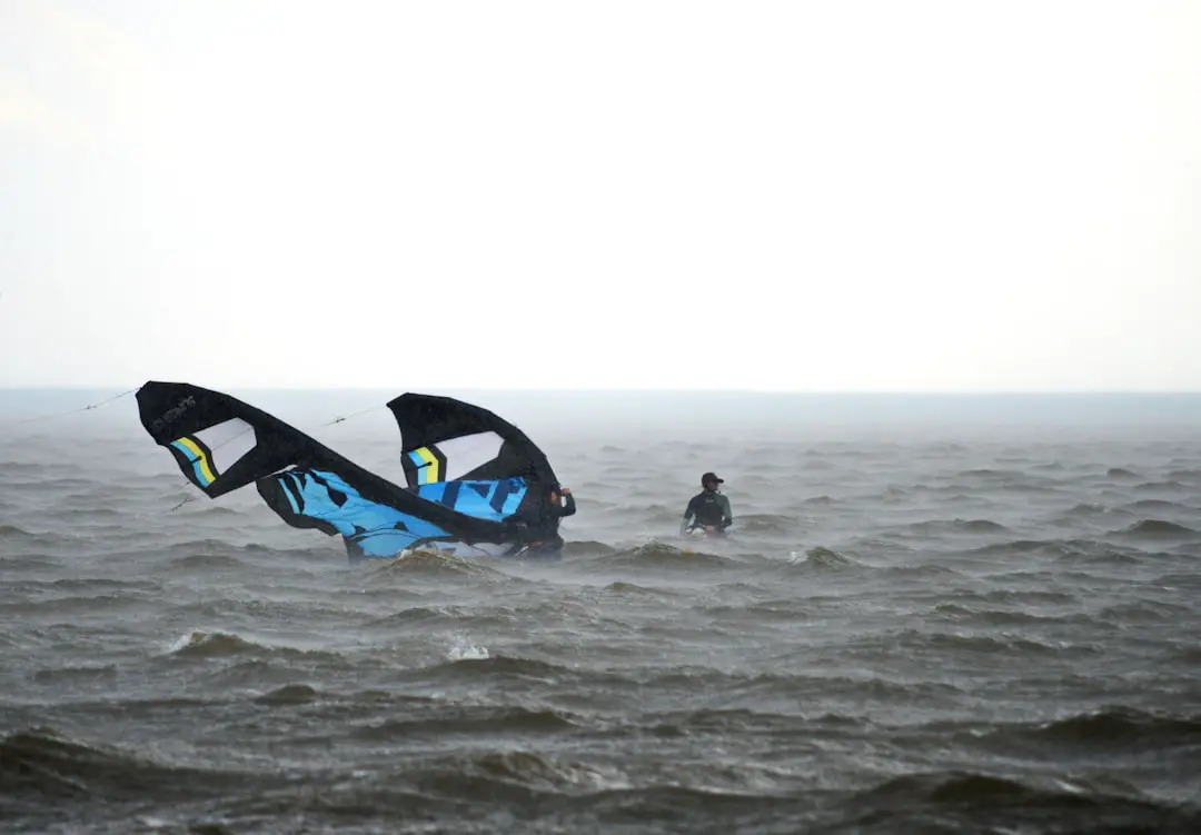two people in the ocean with a large kite