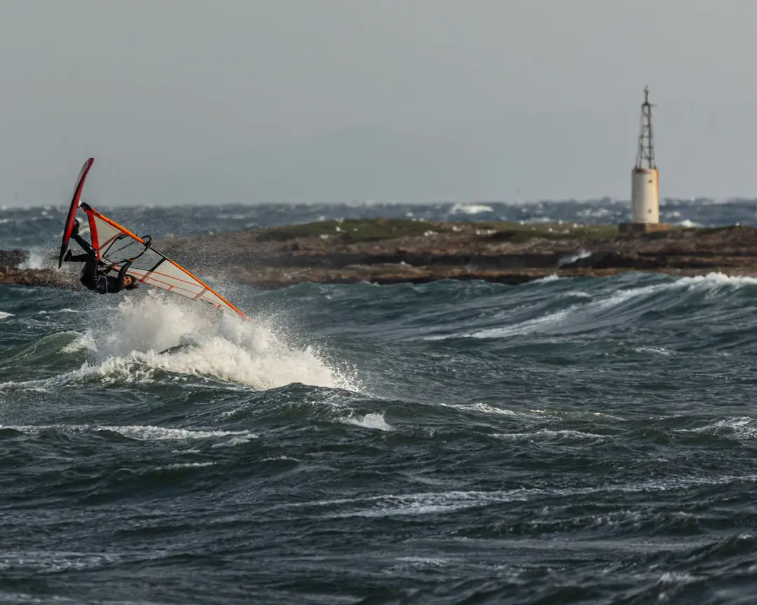FAQ: Your Burning Questions Answered by Hydrofoiling Windsurfer catches air on a choppy ocean.