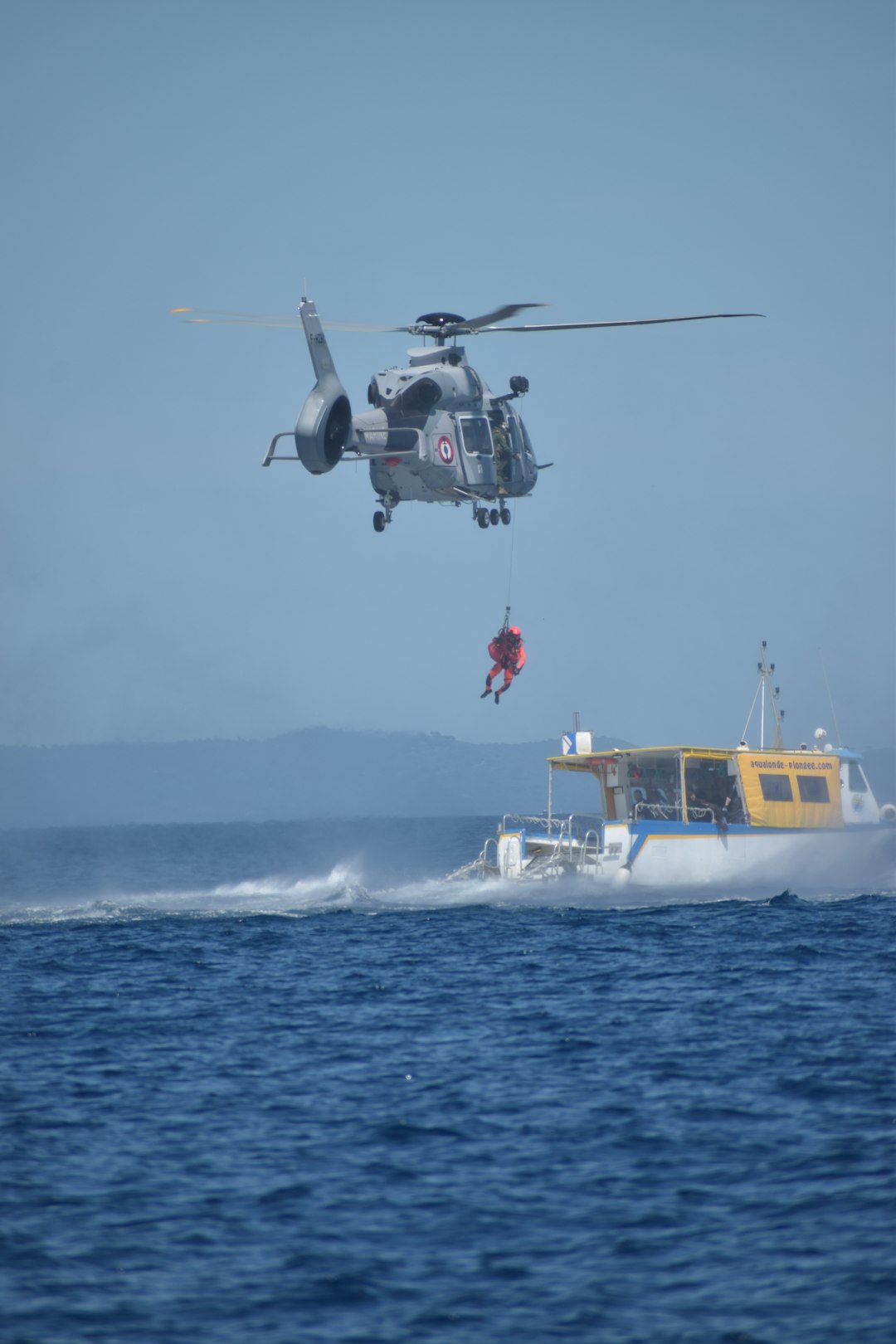 A helicopter rescues someone from the water.
