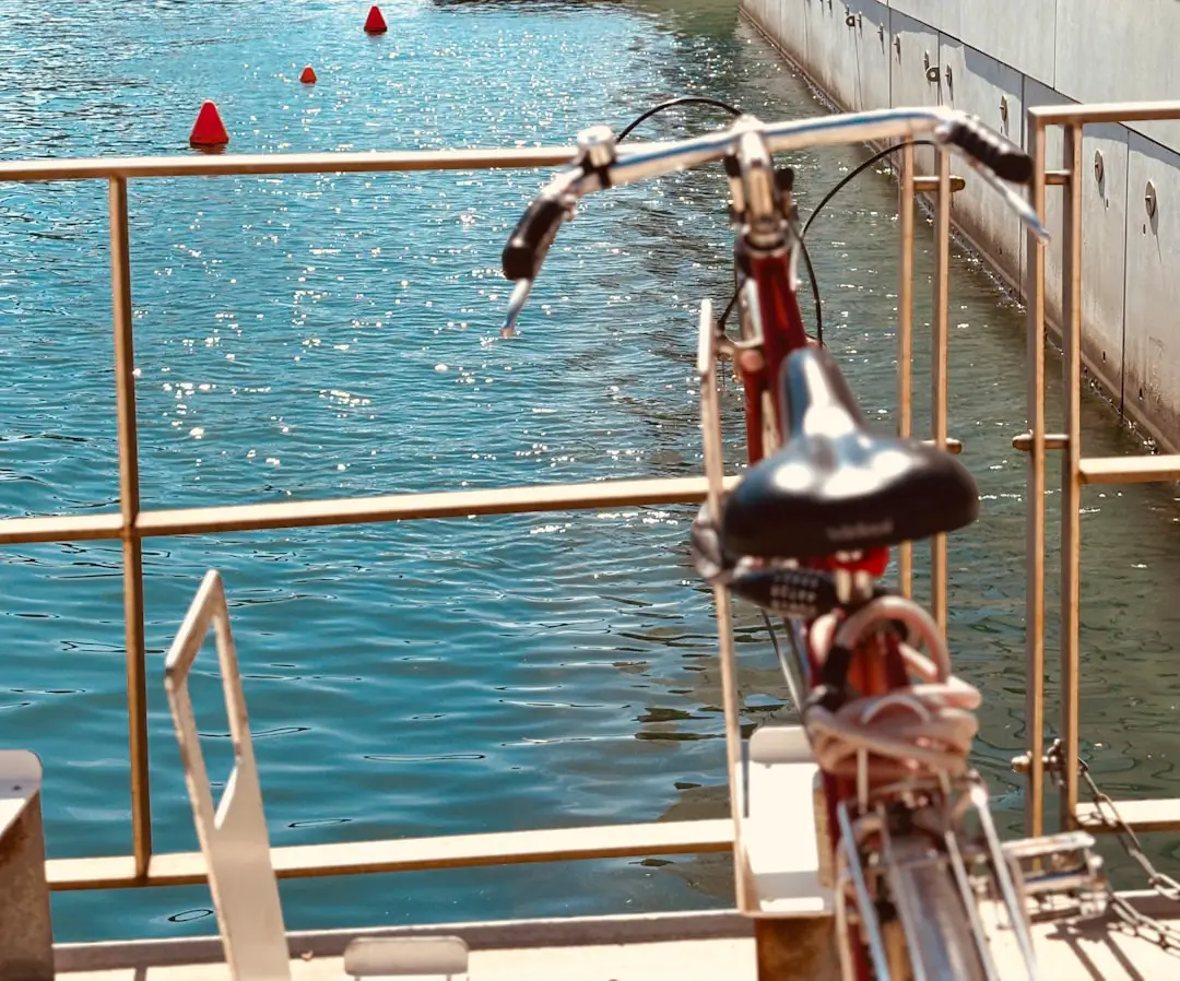 A bicycle parked next to a railing near a body of water