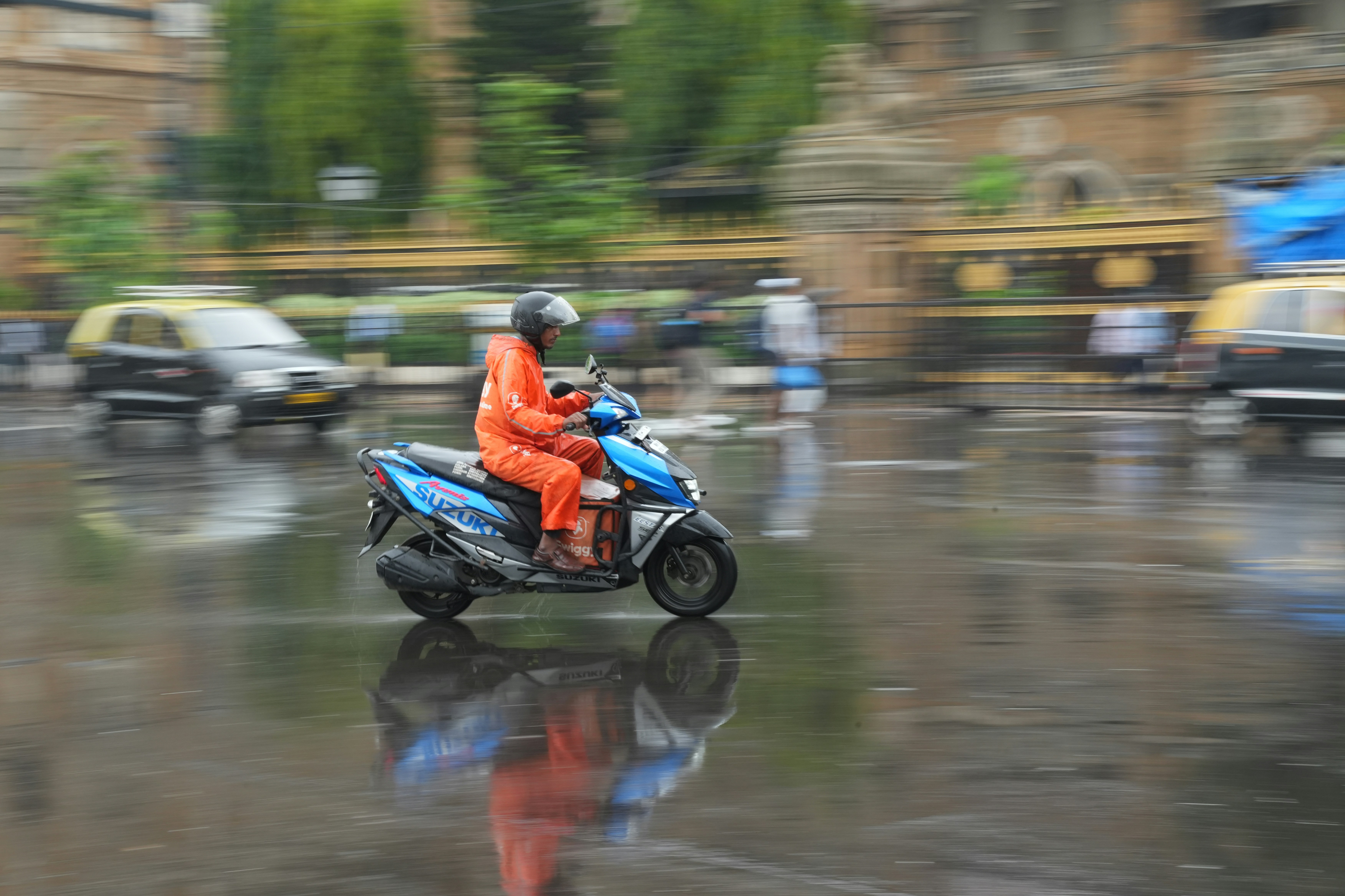 A motorcyclist rides through the rain.